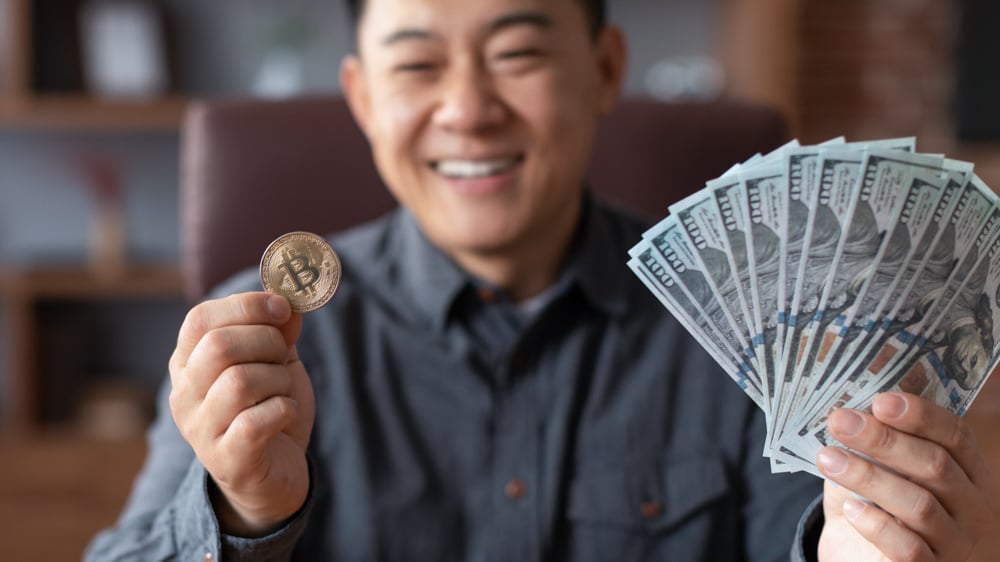 smiling-mature-japanese-businessman-hold-bitcoin-c-2023-11-27-04-50-17-utc